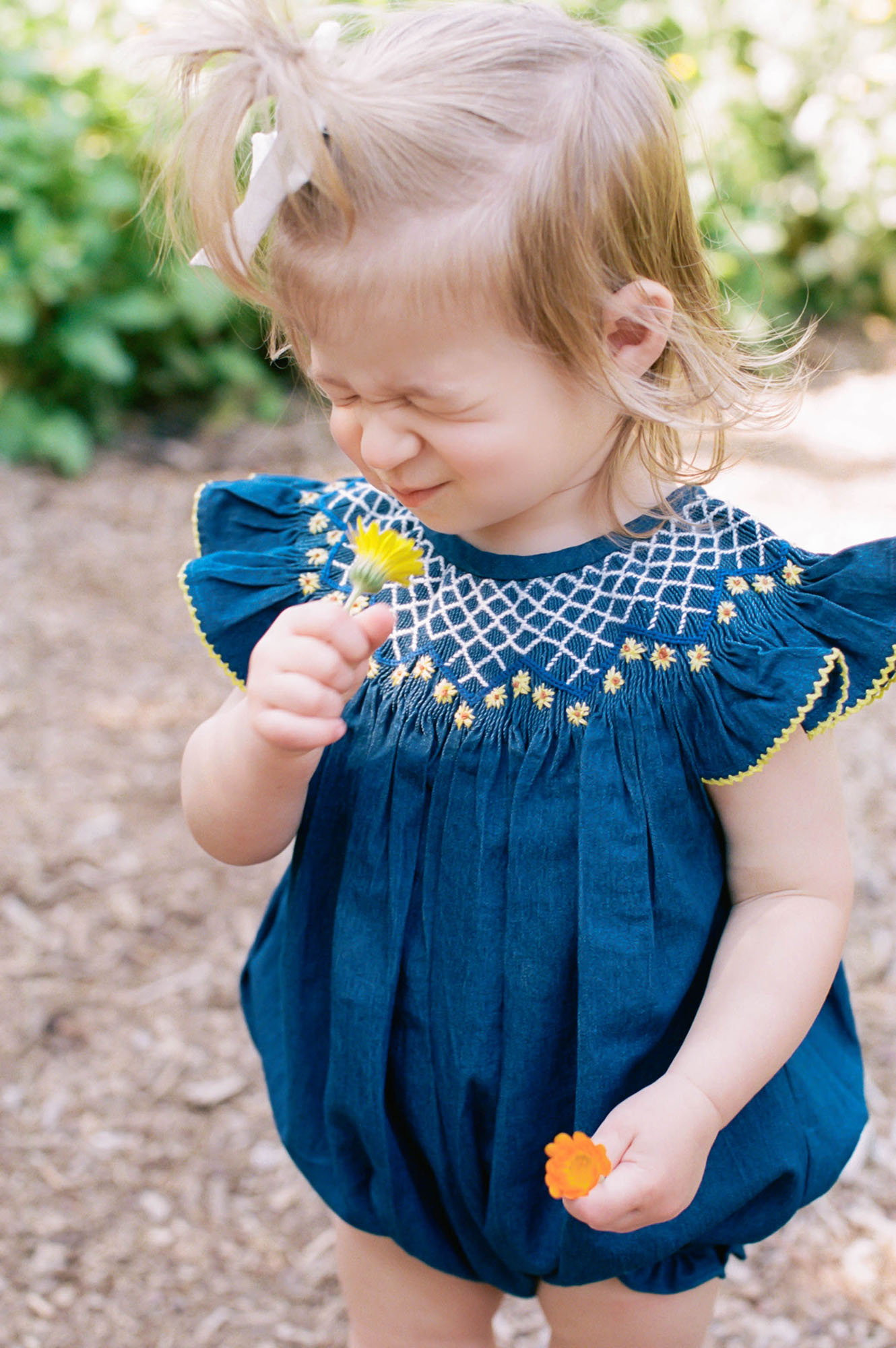 Portland-family-photographer-toddler girl in blue romper in garden
